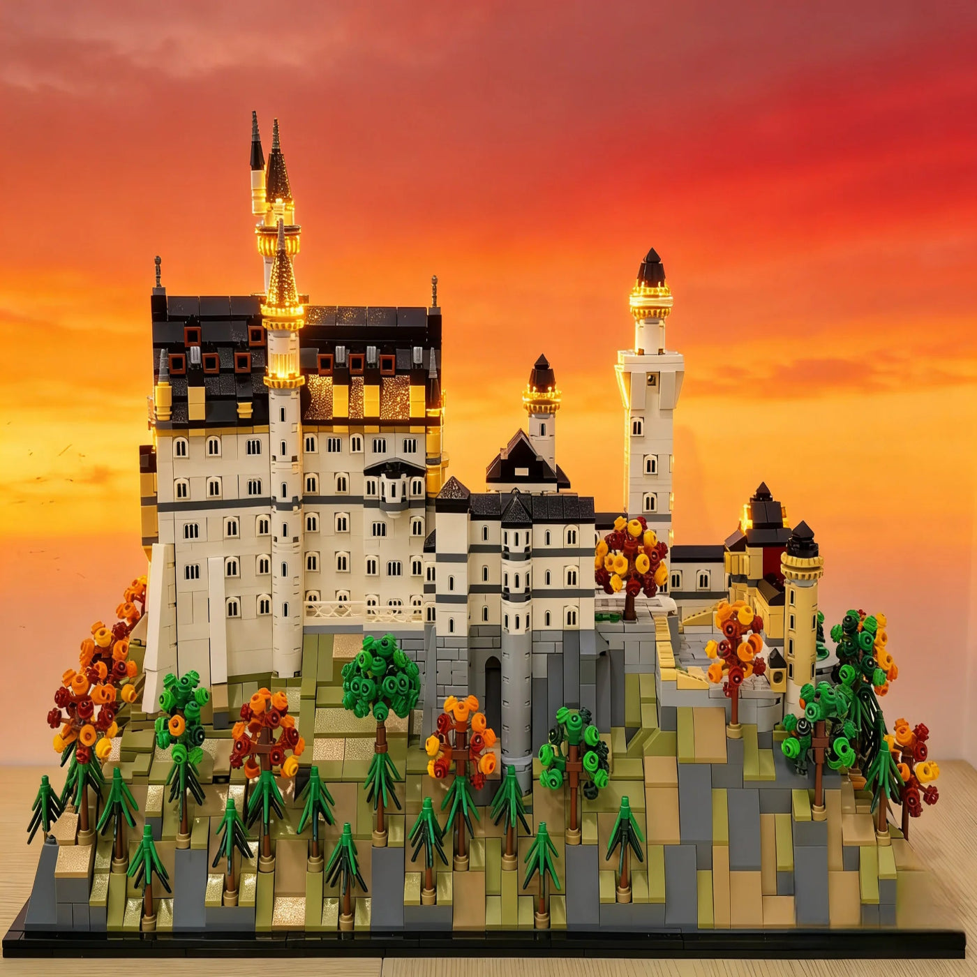 Model of a castle with trees against an orange sunset sky